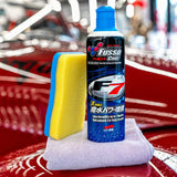 Soft99 Fusso Coat F7 sealant with application sponge and microfiber cloth on a red car.