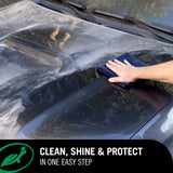 Hand using a blue microfiber cloth to wipe and shine a car hood with Turtle Wax 1 & Done Detailer.