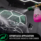 Foam cannon spraying pink car wash foam on a black car, effortless car detailing application.