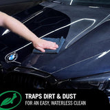 Hand using a microfiber cloth to wipe a black car hood with Turtle Wax Ceramic 3in1 Detailer.