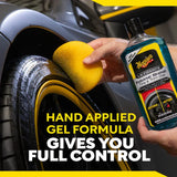 Hand applying tire shine gel with sponge for car detailing
