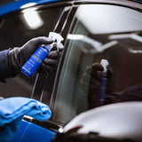 Hand applying Labocosmetica AQUAVÈLOX Glass Nano Sealant to a car window.