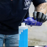 Pouring Labocosmetica ÈNERGO Mineral Stain Remover into a graduated measuring bottle.