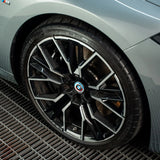 Close-up of a glossy black and silver alloy wheel and tire treated with Labocosmetica sealant.