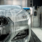 Close-up of a car front end covered in Labocosmetica PRÌMUS 2.0 snow foam prewash.