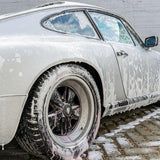 White car covered in Labocosmetica PRÌMUS 2.0 prewash foam during detailing.