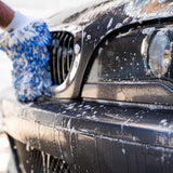 Washing a black car with a blue microfiber mitt and Gyeon soapy foam